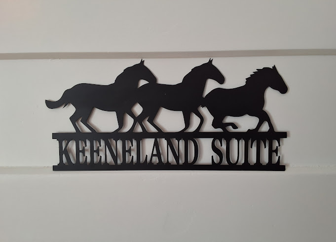 Laser-cut metal sign featuring running horses and the words Keeneland Suite.