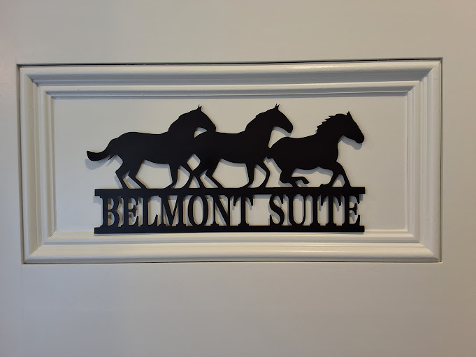 Laser-cut metal sign featuring running horses and the words Belmont Suite.