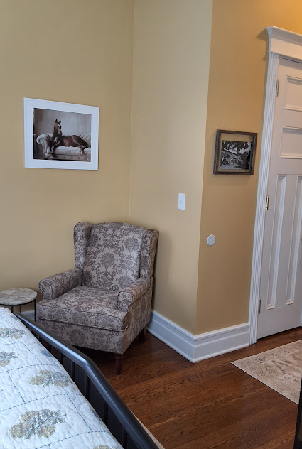 Cozy corner in bedroom with upholstered floral armchair.
