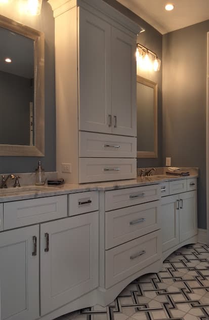 Double-sink bathroom vanity with wall-mounted mirrors and white cabinetry.