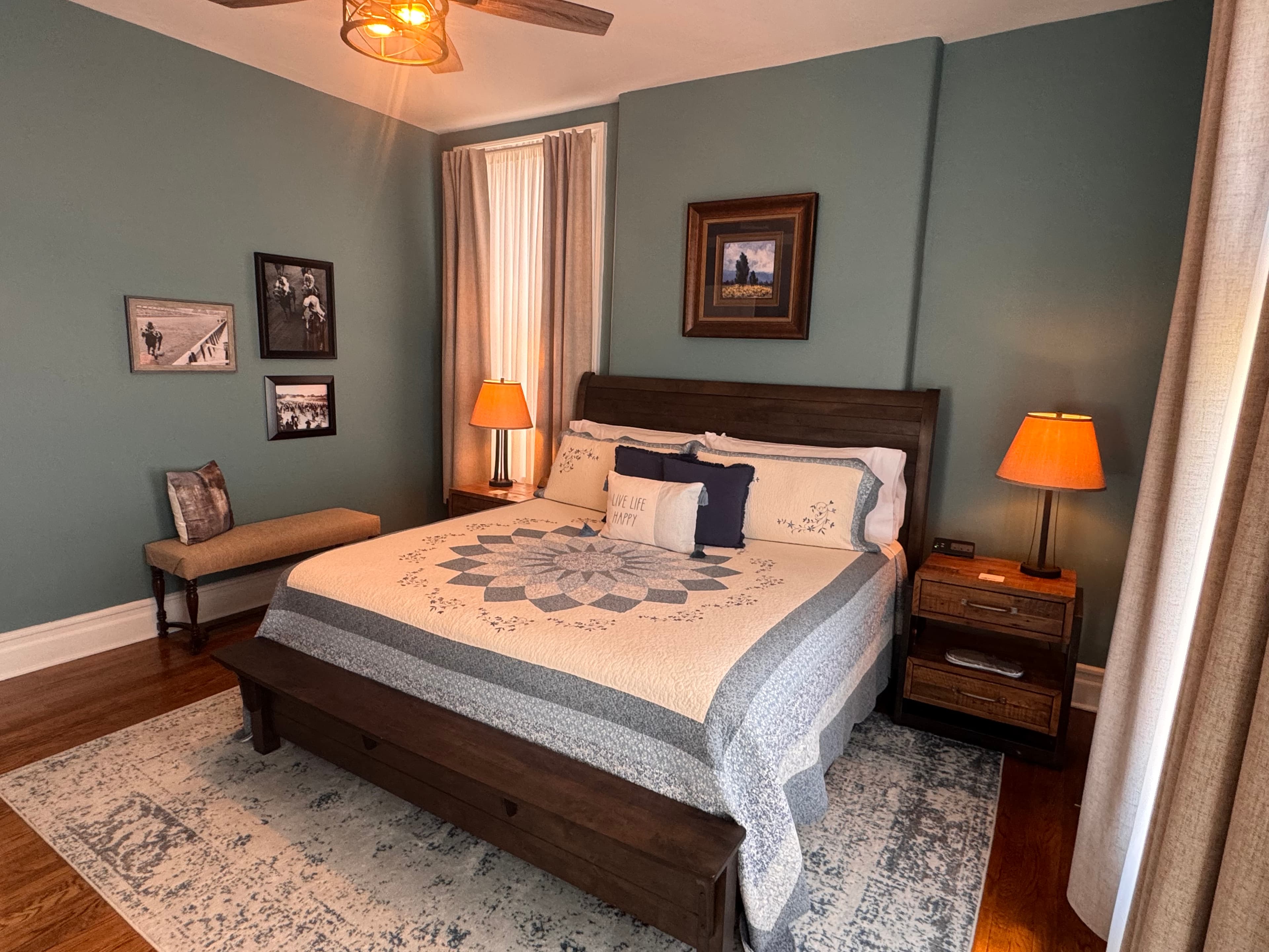 An inviting king-size bed topped with a beautiful quilt and flanked by nightstands with lamps.