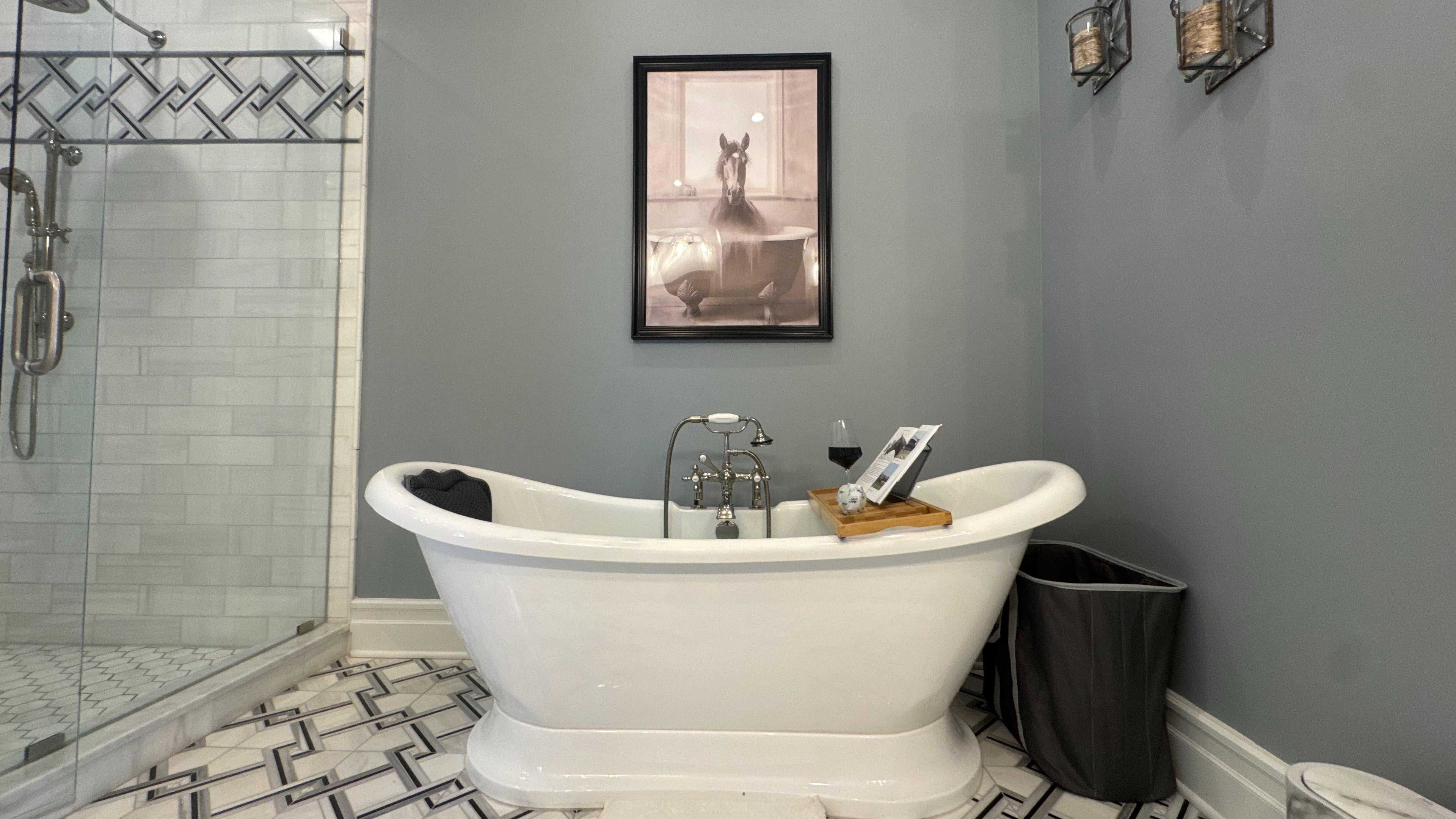 Spa-like bathroom with white slipper soaking tub and beautiful gray and white tiled floor.