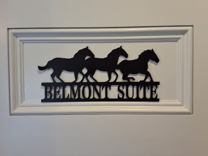 Laser-cut metal sign featuring running horses and the words Belmont Suite.