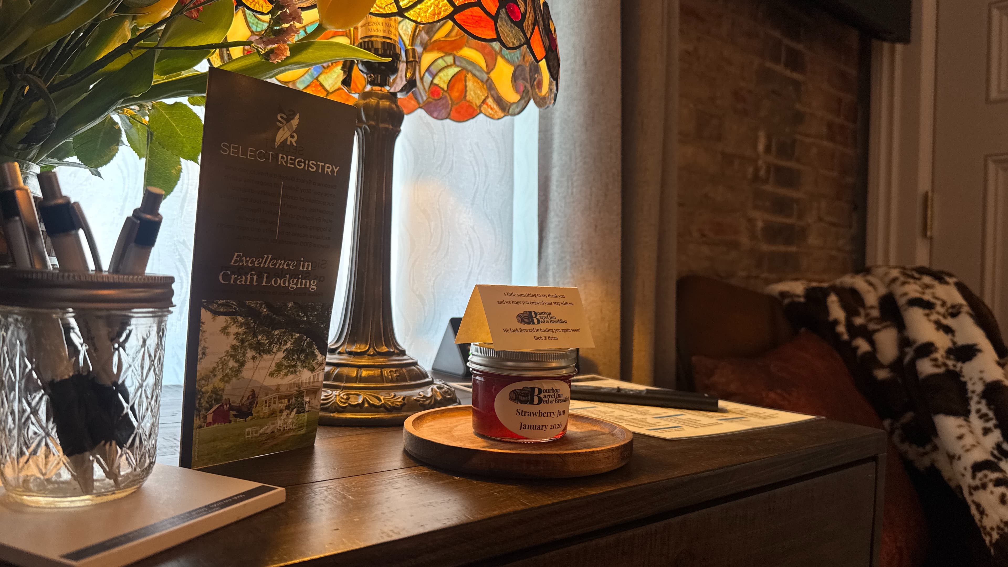 Detail photo of a stained glass lamp and a jar of homemade cherry bourbon jam.