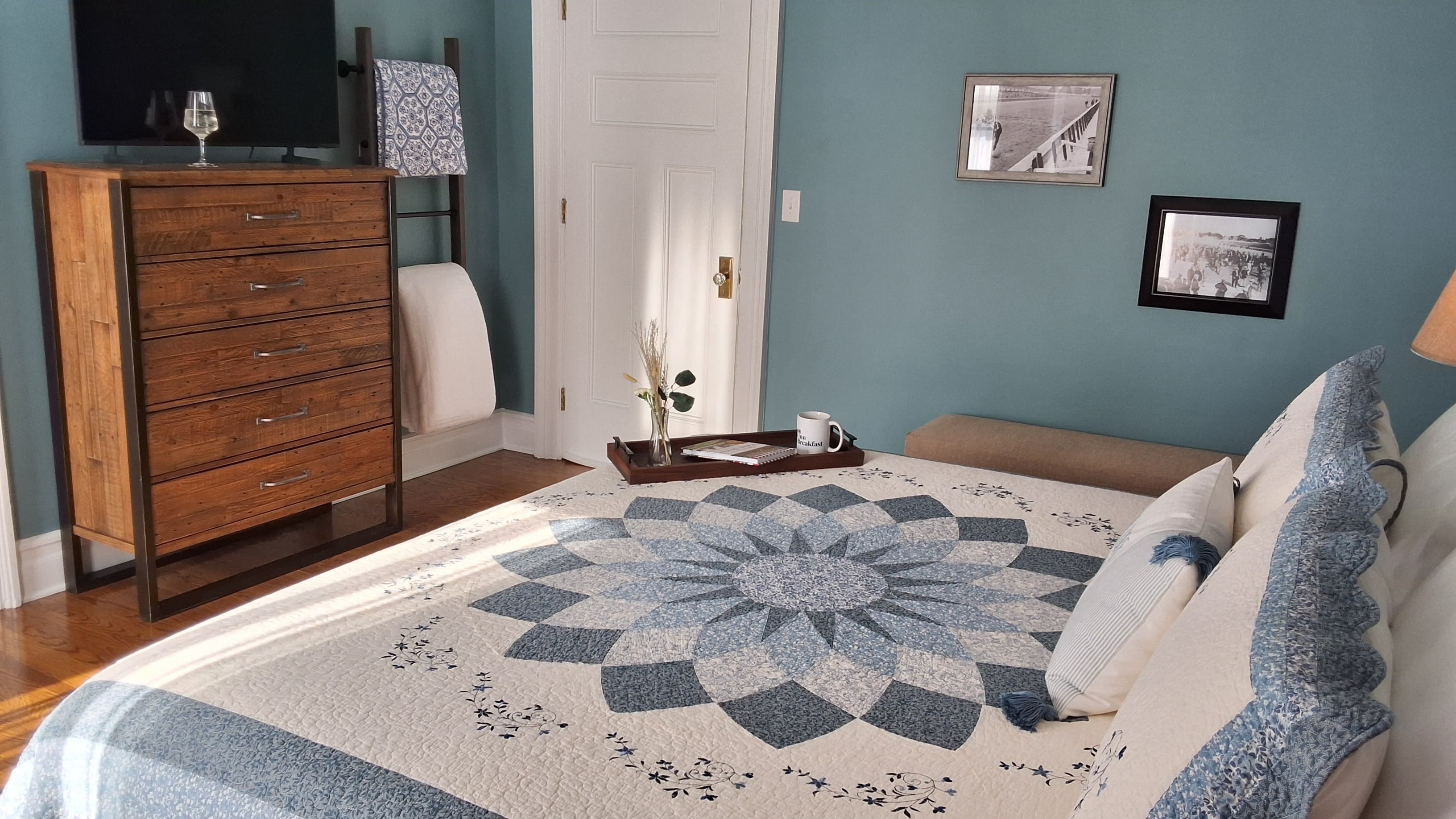 An inviting king-size bed topped with a beautiful quilt and flanked by nightstands with lamps.