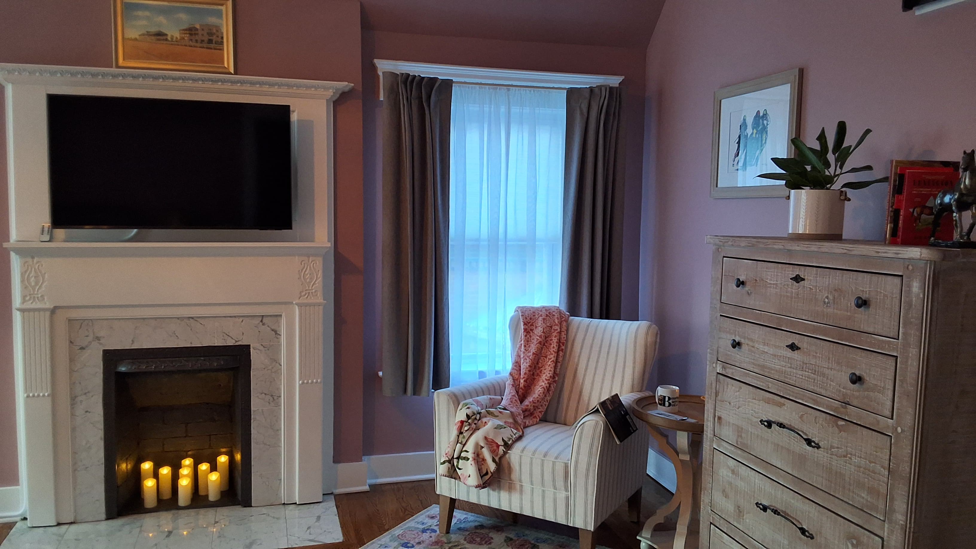 Cozy sitting area with upholstered armchairs, hardwood floors, and floor to ceiling windows.