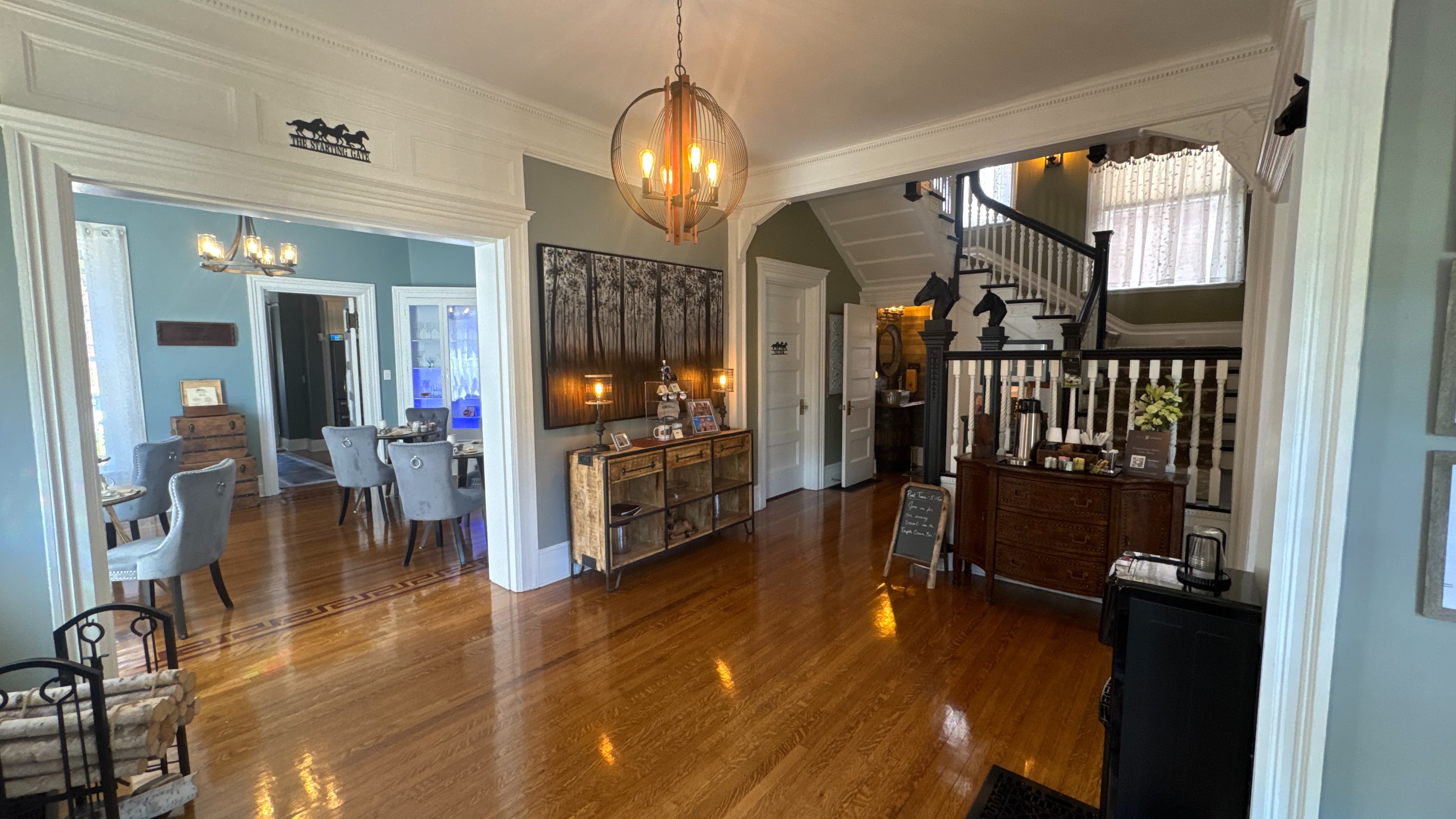 A spacious, well-lit entryway showing a view of a dining area and an elegant staircase.