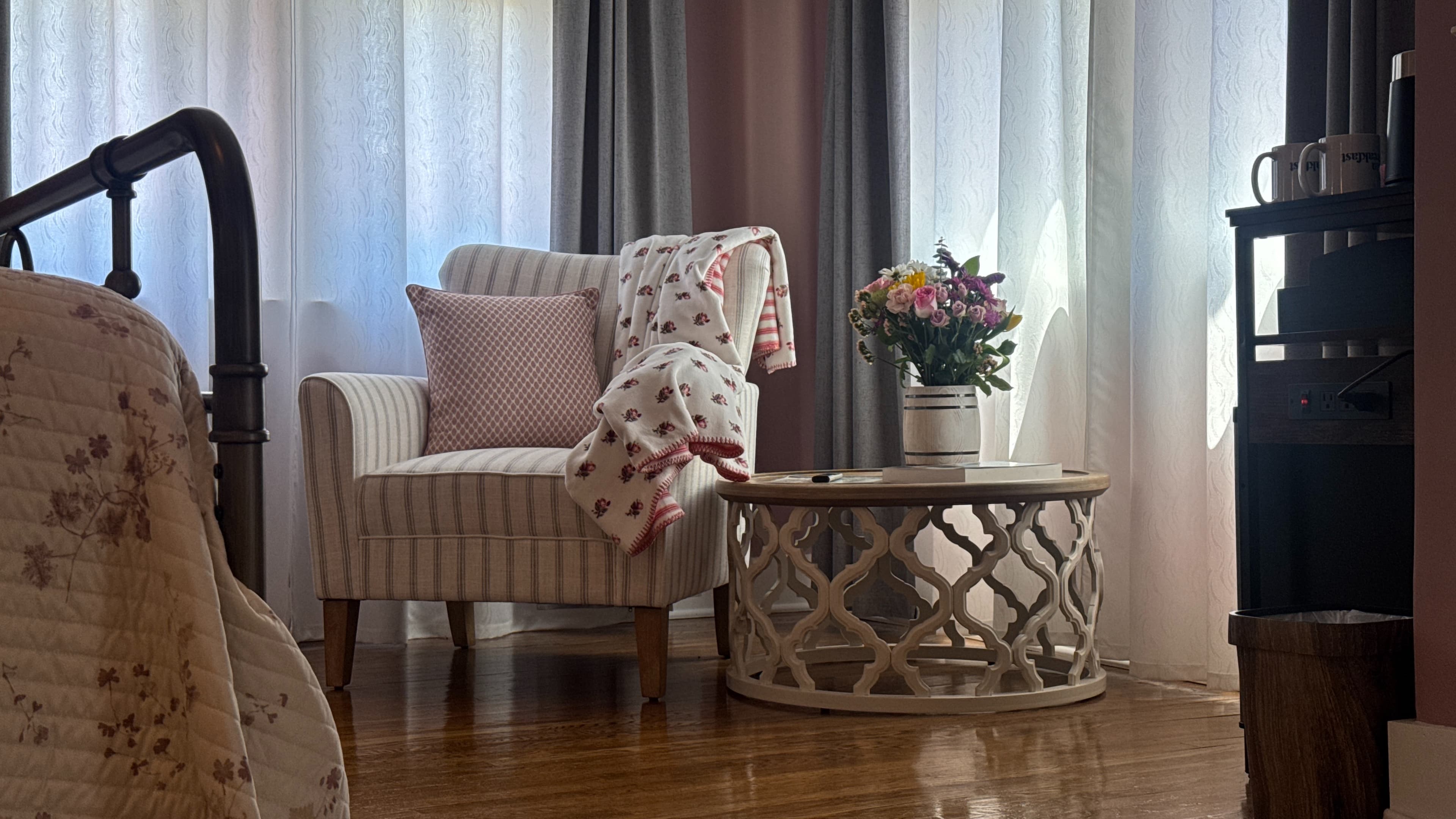 Cozy sitting area with upholstered armchairs, hardwood floors, and floor to ceiling windows.