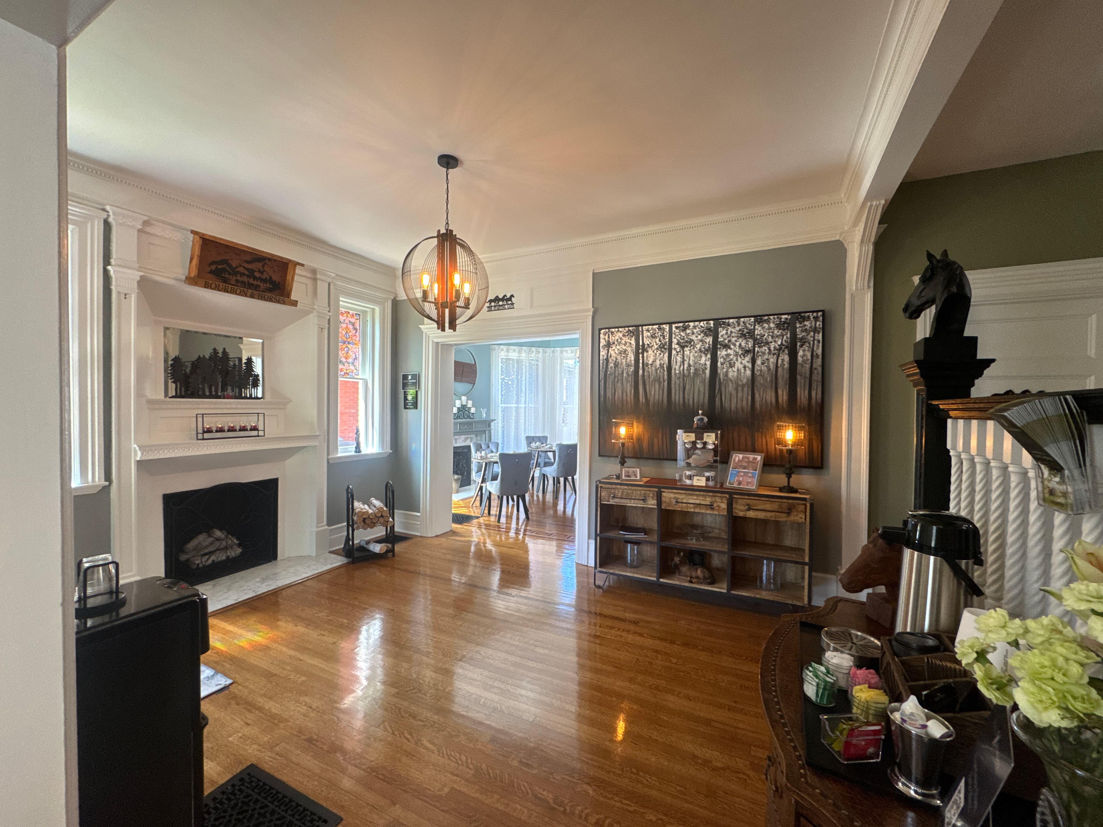 A spacious living room featuring a fireplace, decorative shelving, and a view into a dining area.