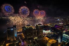 Fireworks illuminate the night sky over a city skyline. Fireworks illuminate the night sky over a city skyline.