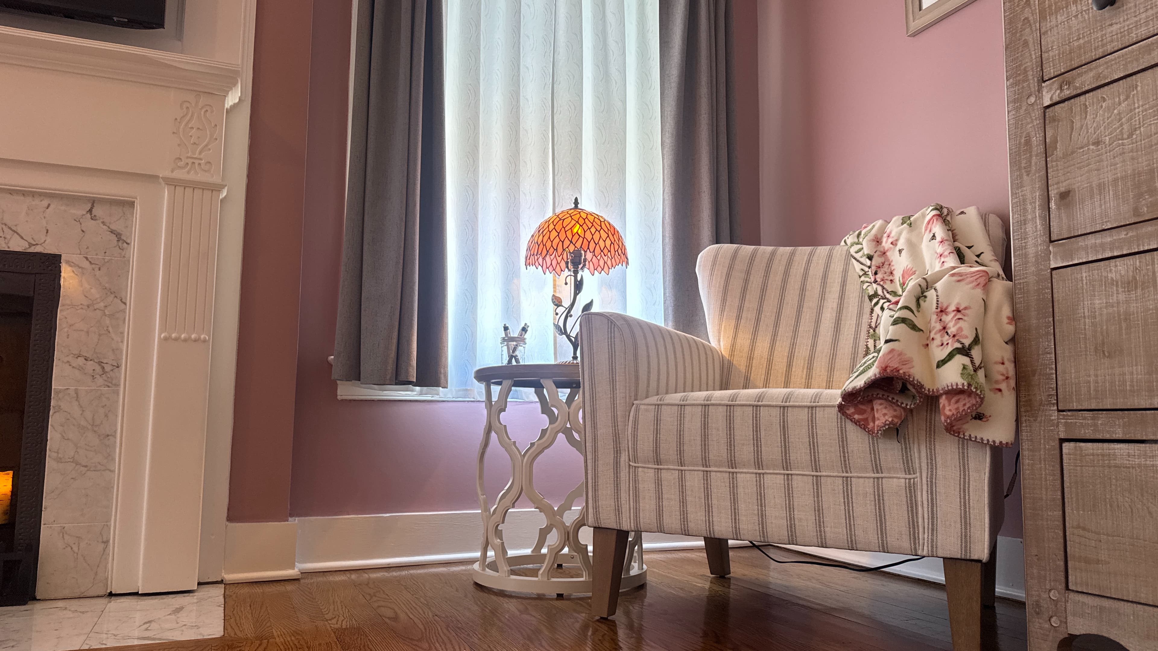 Cozy sitting area with upholstered armchairs, hardwood floors, and windows.