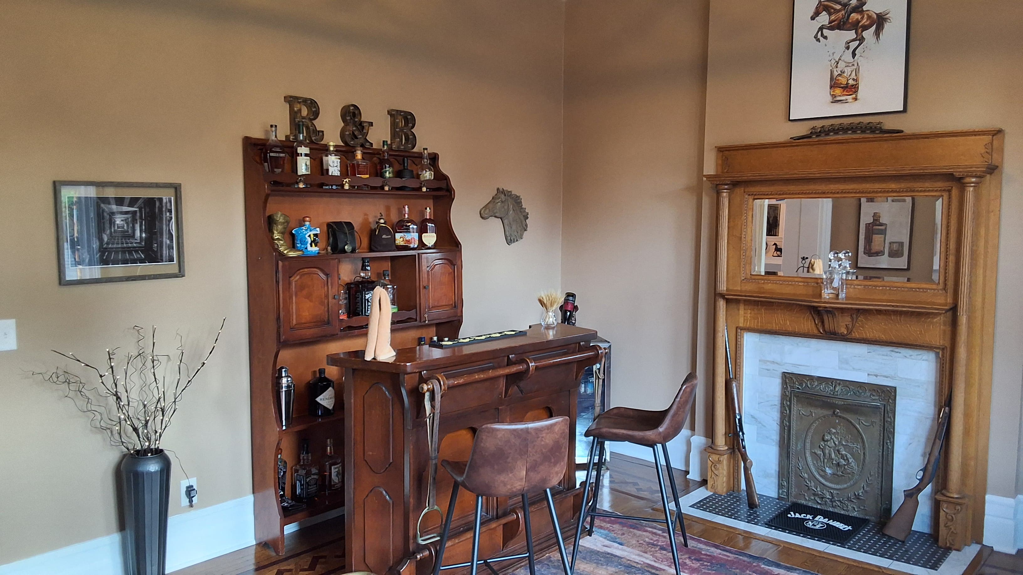 A cozy home bar featuring a wooden counter, various liquor bottles, and decorative elements like a horse head and vintage mirrors.